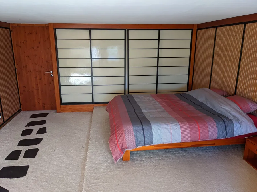 La chambre japonaise : lit bas en bois, cloisons coulissantes de style shoji et panneaux de bambou