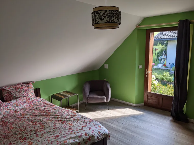 The green room: green wall under the eaves, armchair and garden door