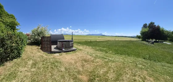 Le sauna et le jacuzzi au bord du champ en été, face au plateau